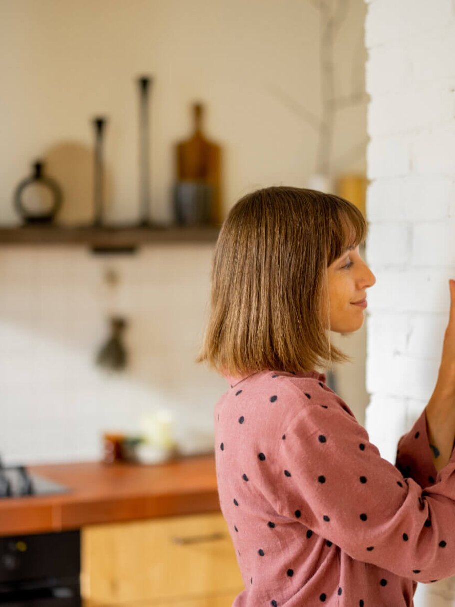 Frau mit Smarthome nutzt Tablet für Temperaturregelung zuhause