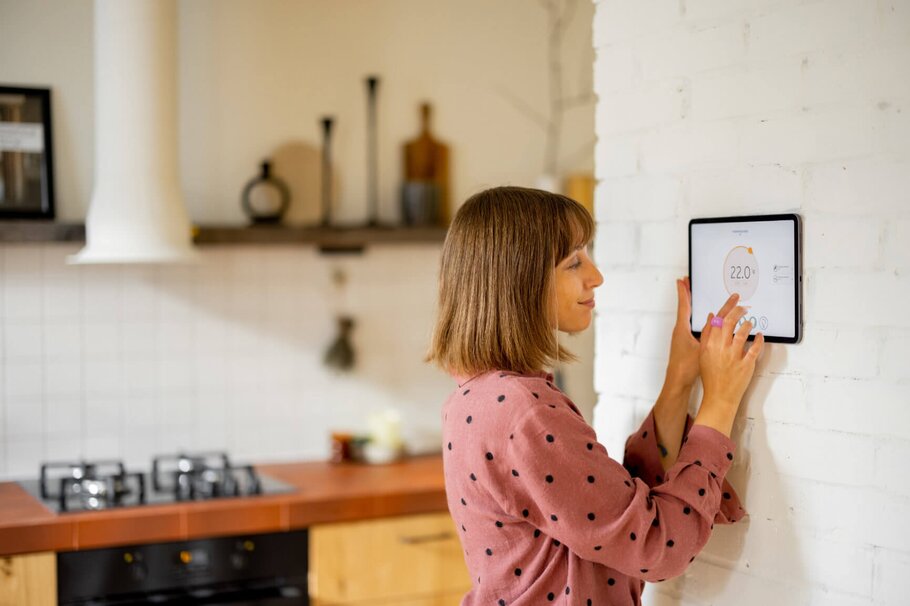 Frau mit Smarthome nutzt Tablet für Temperaturregelung zuhause